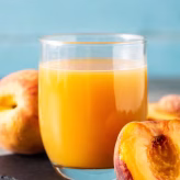 jugo-durazno-natural-vidrio-sobre-mesa-madera_123827-22498